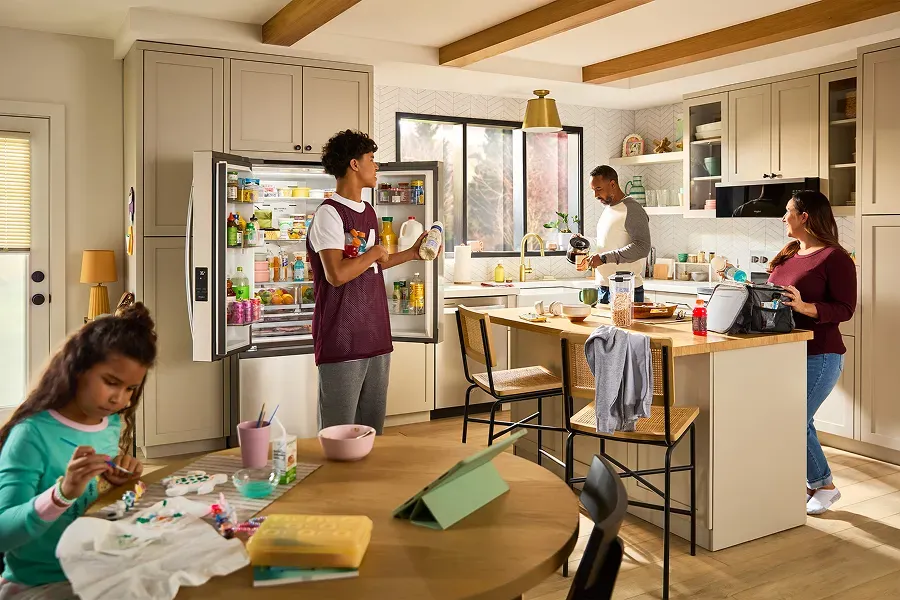 Whirlpool French door refrigerator with open doors in a busy family kitchen showing interior food storage and capacity.